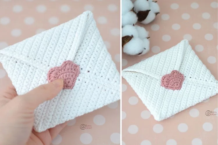 A hand holding a crochet heart on a white envelope.