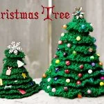 Two green crocheted Christmas trees decorated with beads and felt ornaments sit on a white surface, with the words 