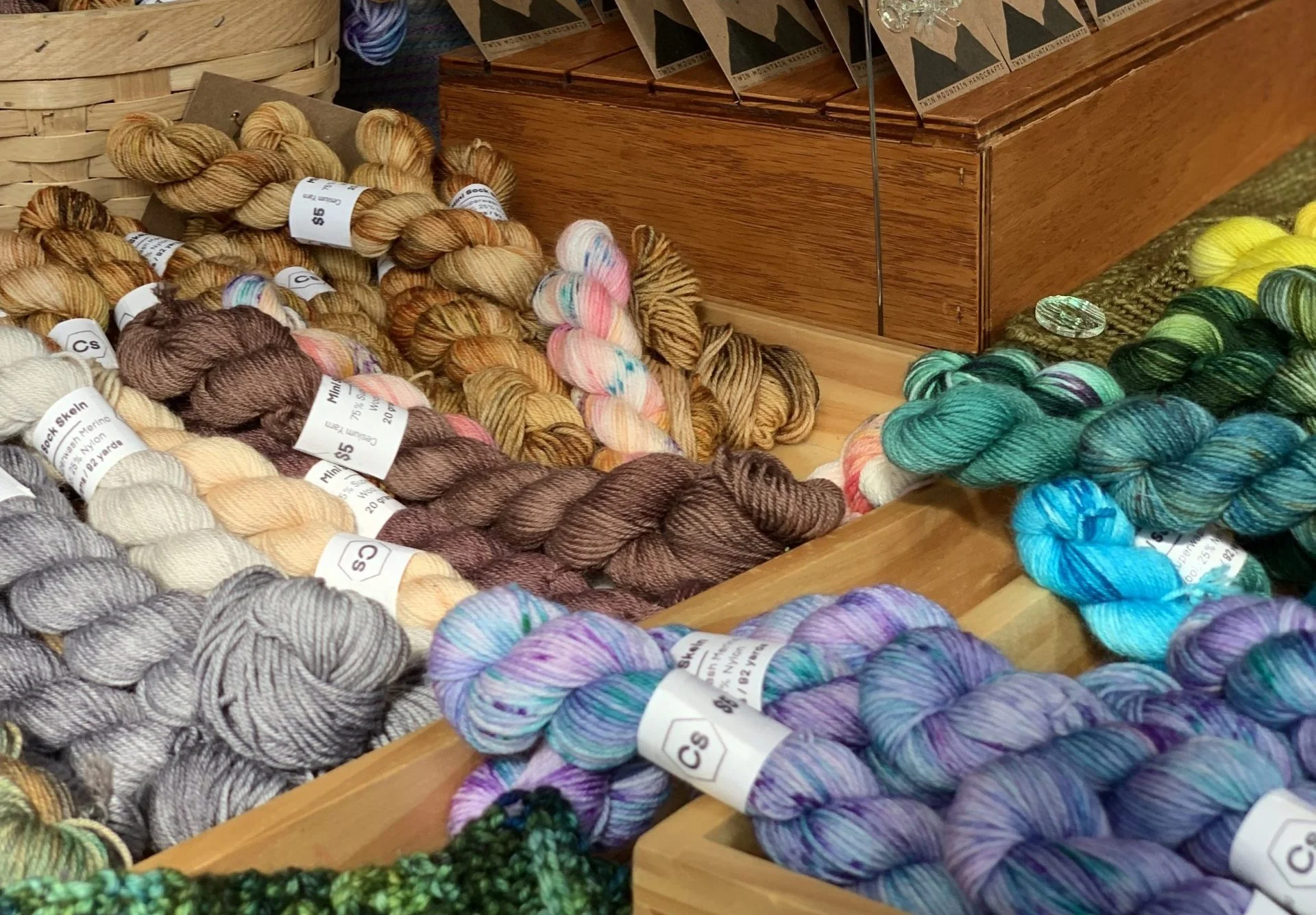 A table filled with colorful yarn skeins for crochet events.