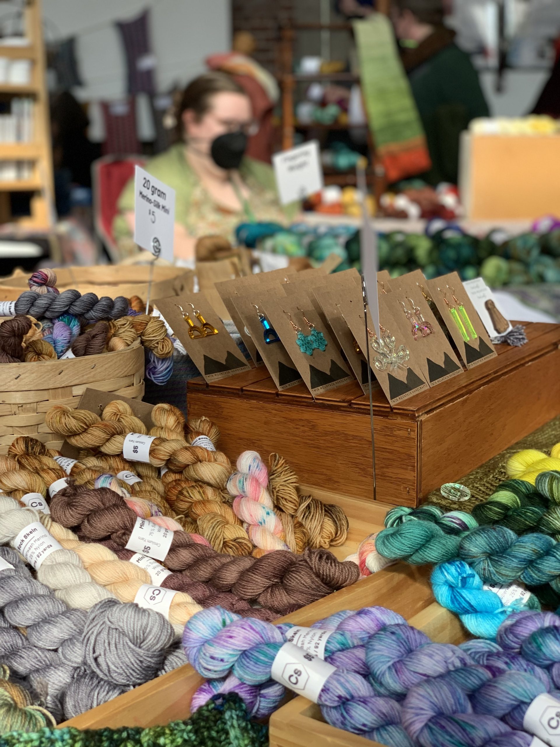 A table filled with colorful yarn skeins for crochet events.