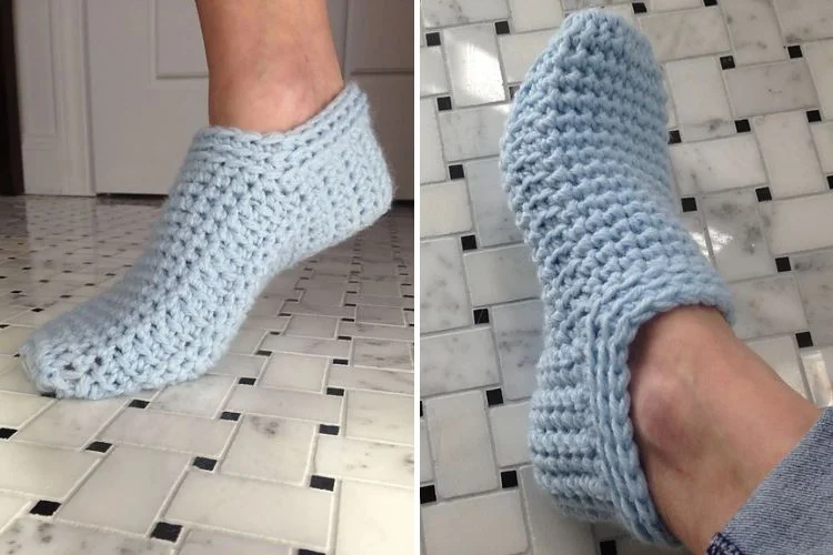 A pair of crocheted slippers on a tile floor.