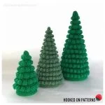 Three green crocheted Tabletop Christmas Tree Cones of varying heights are displayed against a plain white background.