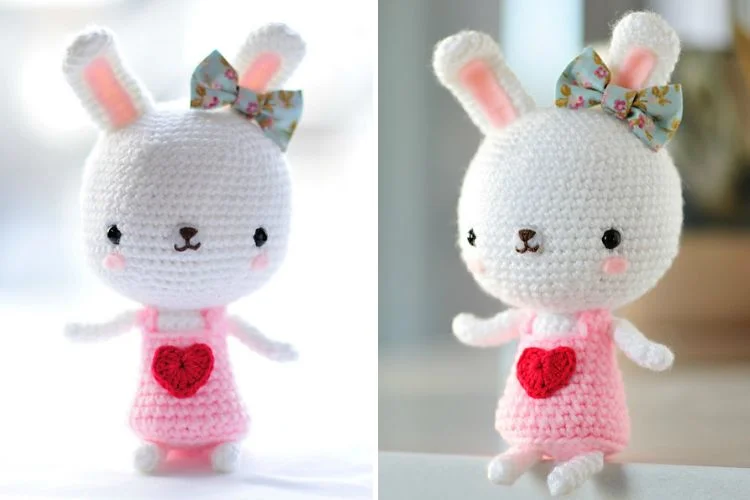 A crocheted bunny with a pink dress and a heart.