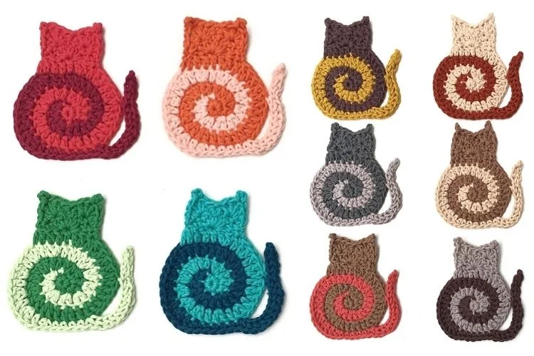 A set of crocheted cat coasters in different colors.