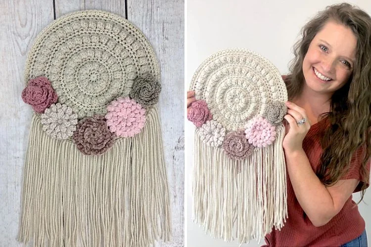 A woman is holding up a crocheted flower wall hanging.