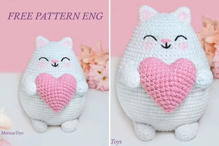 Two crocheted cats with a heart in their hands.