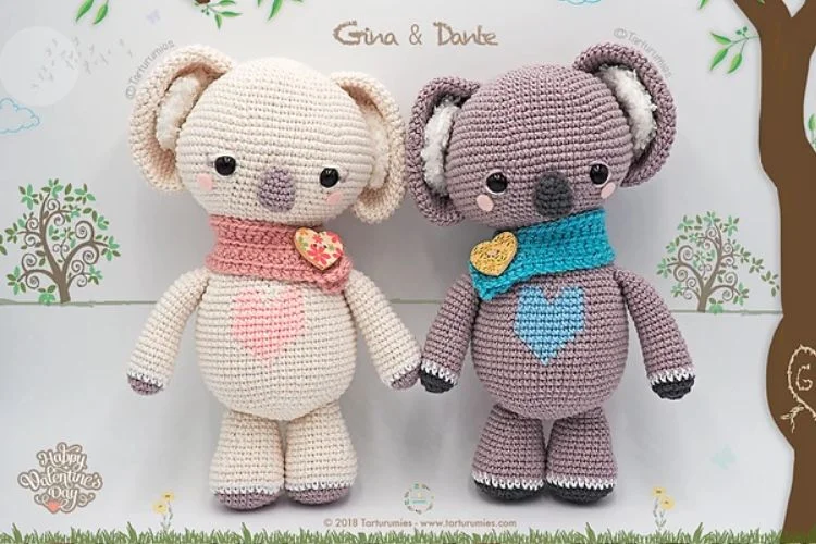 Two crocheted koalas standing next to each other.