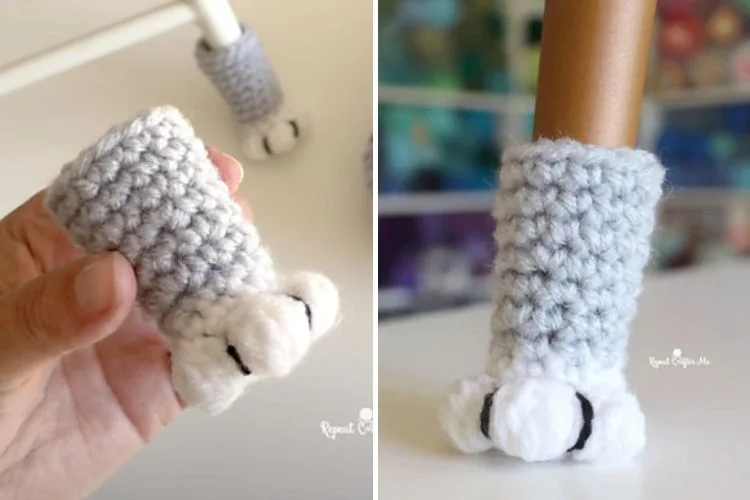 A hand holding a crocheted cat paw.