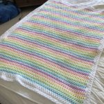 a rainbow-colored crochet baby blanket