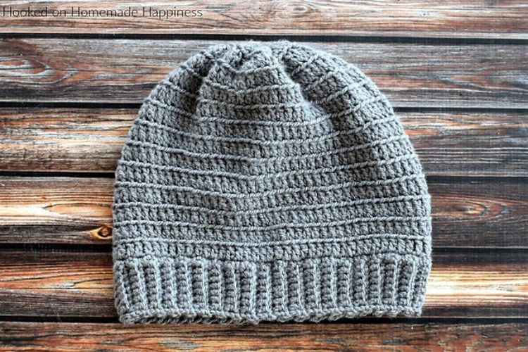 A gray crochet beanie on a wooden table.