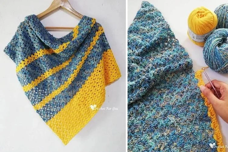 A blue and yellow crocheted shawl hanging on a hook.