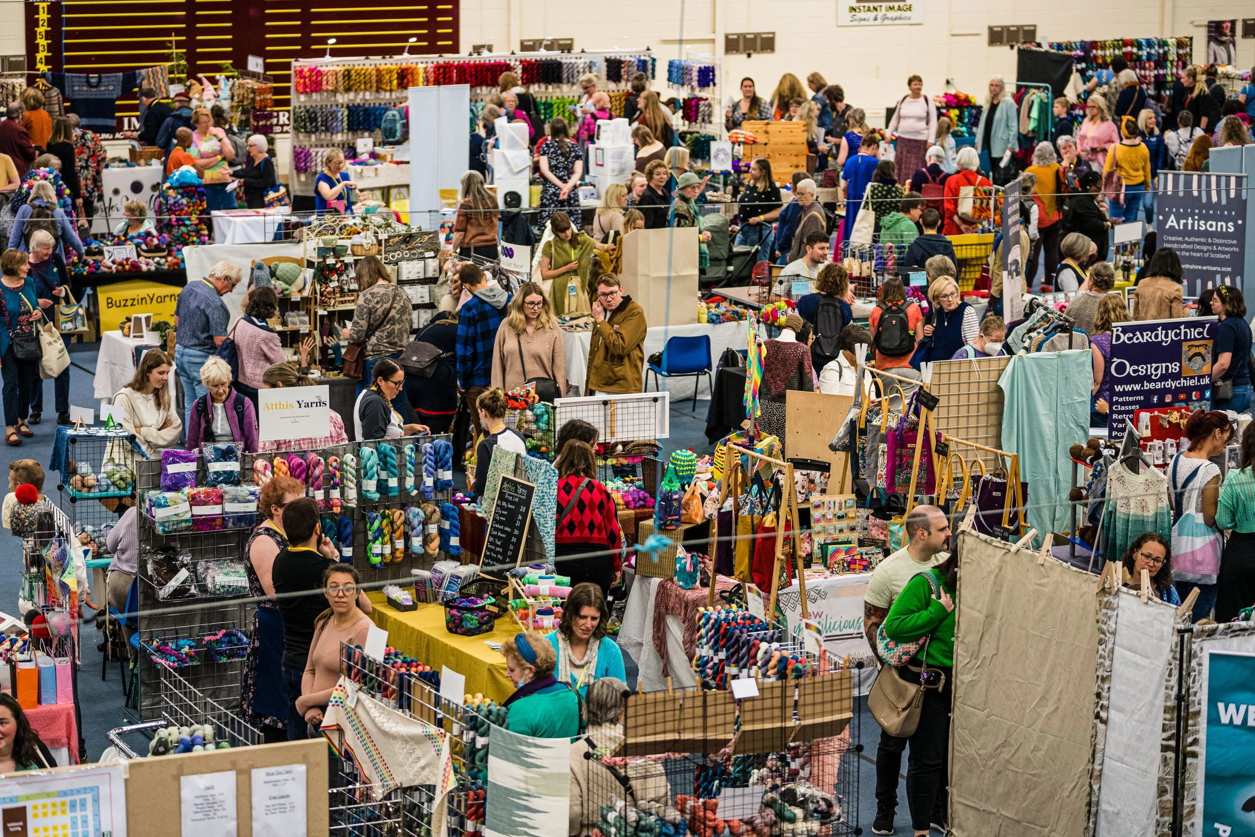 A large crowd of people at a crochet craft fair.