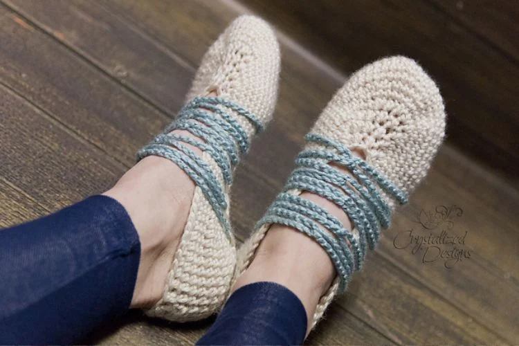 A woman wearing knitted slippers on a wooden floor.