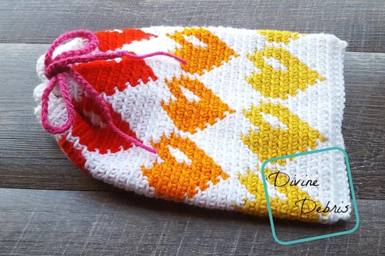 A crocheted beanie with an orange and yellow pattern.