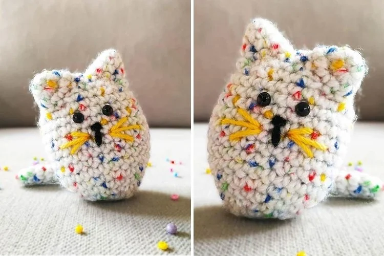 A crocheted cat on a surface.