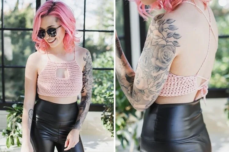 A woman with pink hair and black leather pants.