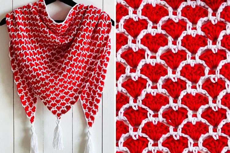 A red and white shawl with tassels hanging on a hanger.