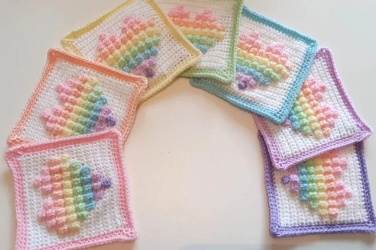 Crocheted rainbow coasters on a white surface.