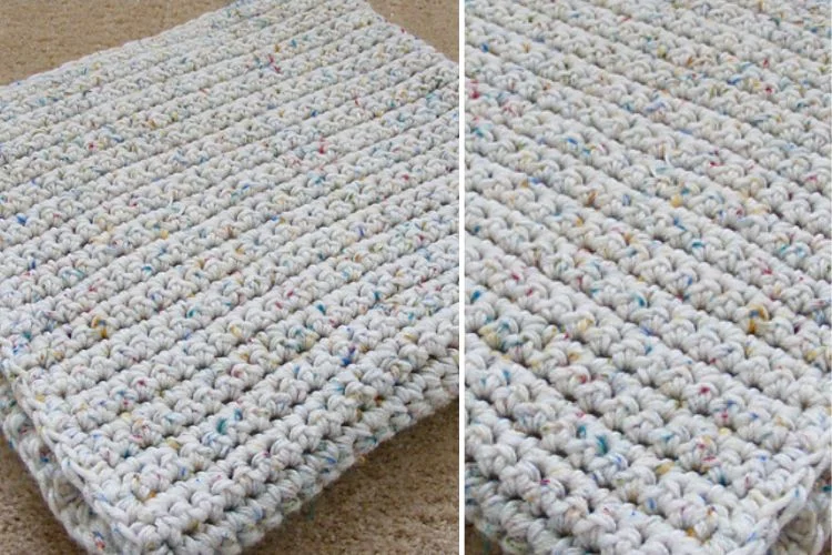 A white crocheted blanket on a carpet.