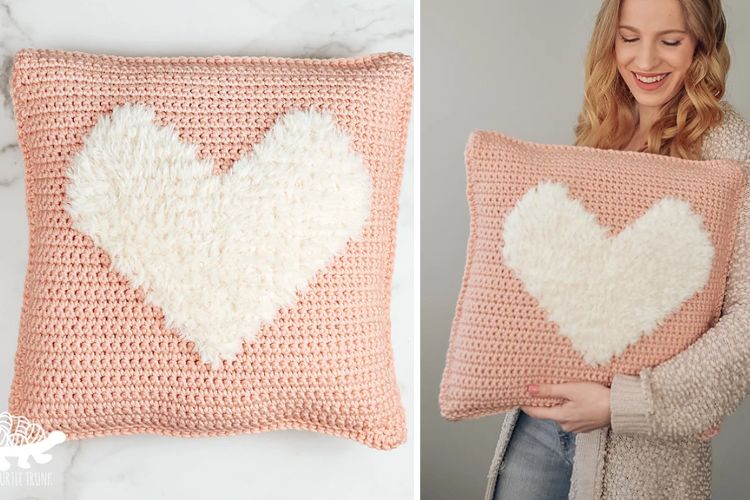 A woman is holding a crocheted heart pillow.