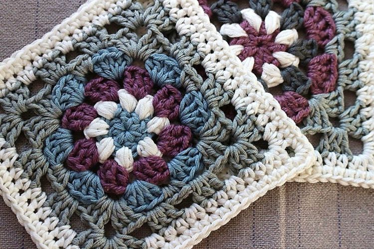 Two crocheted squares with flowers on them.