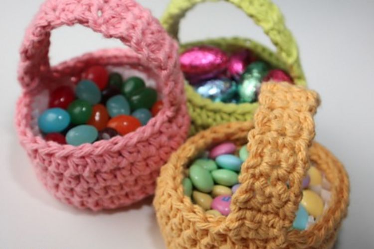 Three crocheted baskets filled with candy.