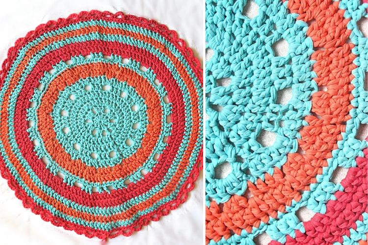 A crocheted circular rug with red, blue, and orange colors.