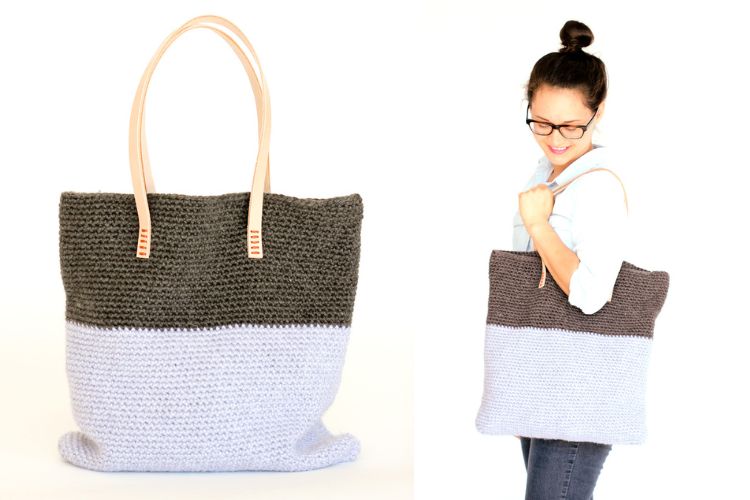 A woman is holding a grey and blue crocheted tote bag.