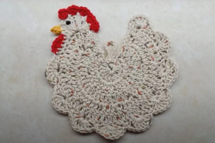 A crocheted rooster on a white surface.