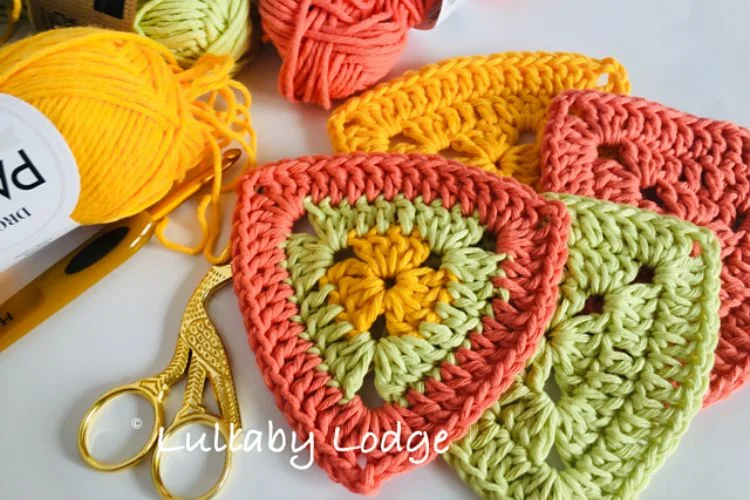 A group of crocheted pieces and scissors on a table.