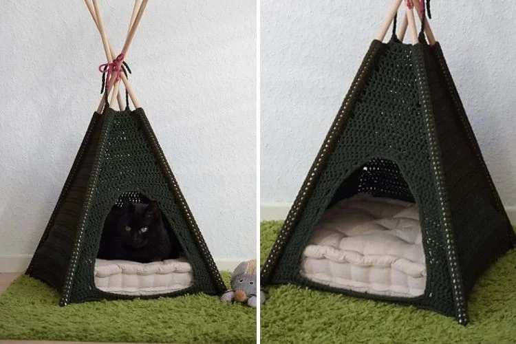 A black cat resting inside a green crochet teepee on a fluffy rug with a toy mouse beside it.