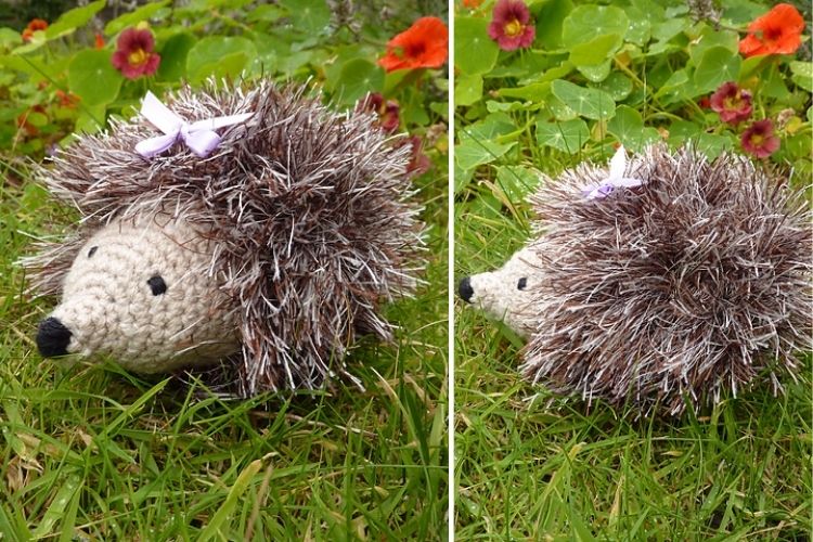 A handmade hedgehog figurine with a purple bow on green grass with flowers in the background.