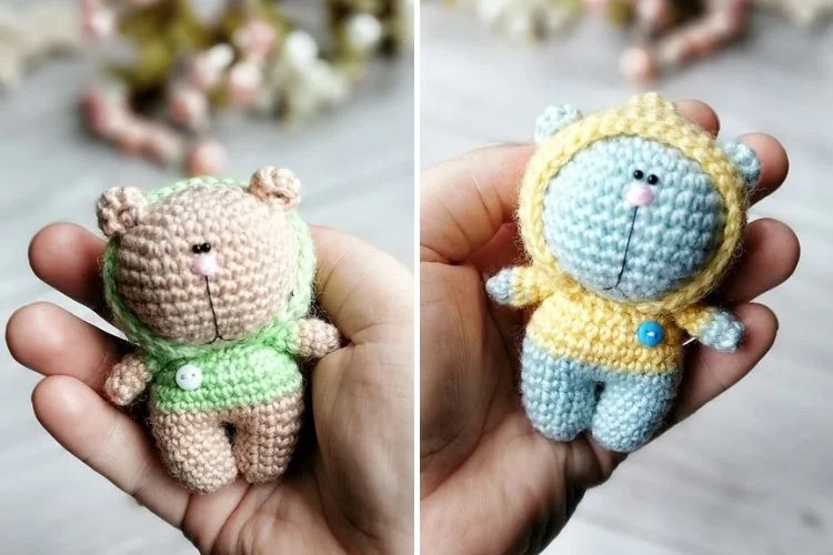 A pair of handmade crochet amigurumi toys, depicting a bear and a cat, cradled in a person's hand.