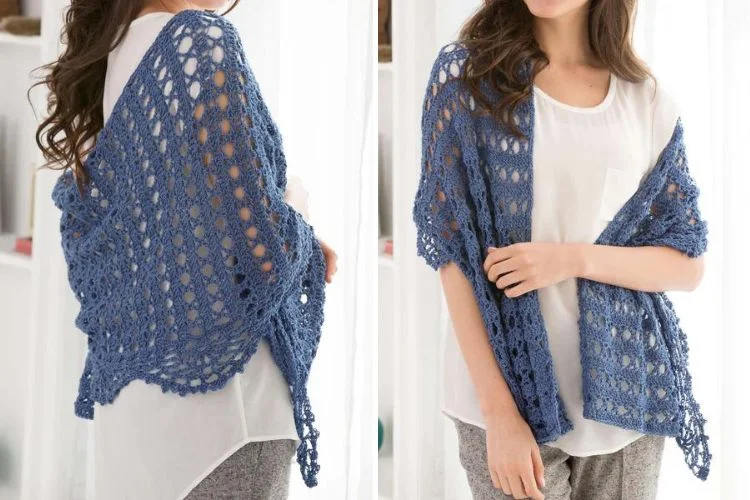 A woman showcasing a navy blue crocheted Quick Weekend Shawl from two angles, highlighting its intricate pattern and how it drapes over a white top.