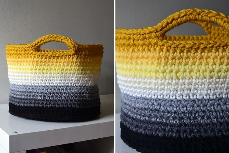 A handmade crochet bag with a gradient color design ranging from black to white with a yellow top displayed on a white surface.