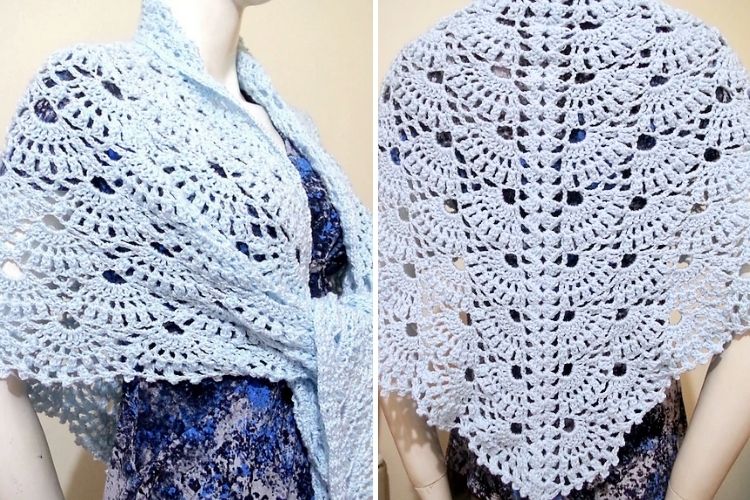 Mannequin displaying a light blue crocheted shawl with intricate lace patterns, draped elegantly over shoulders.