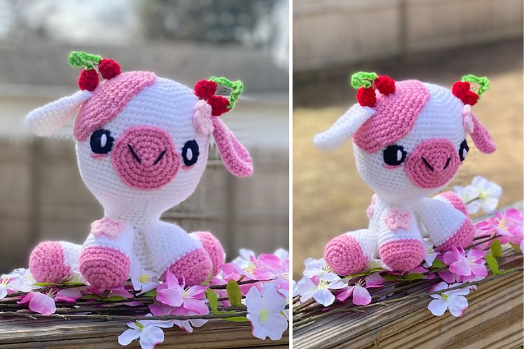 Handmade crocheted pink and white dragon toy with cherry blossoms on a woven branch, outdoors.