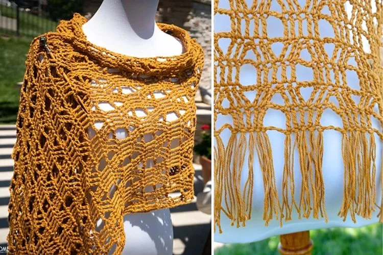 A handmade yellow crochet shawl displayed on a mannequin, highlighting its intricate lace pattern and fringe detailing.