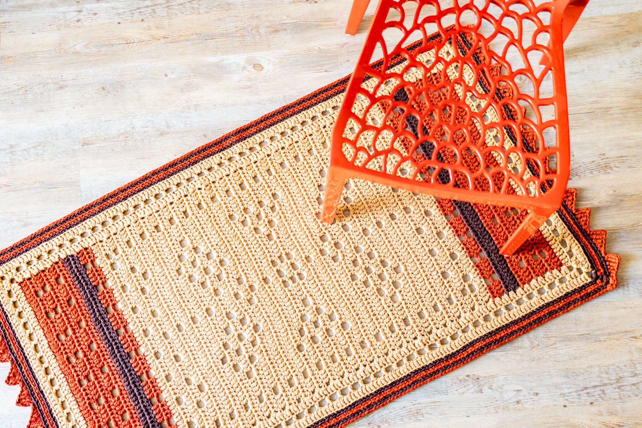 beige and orange crochet rug with mesh orange chair 