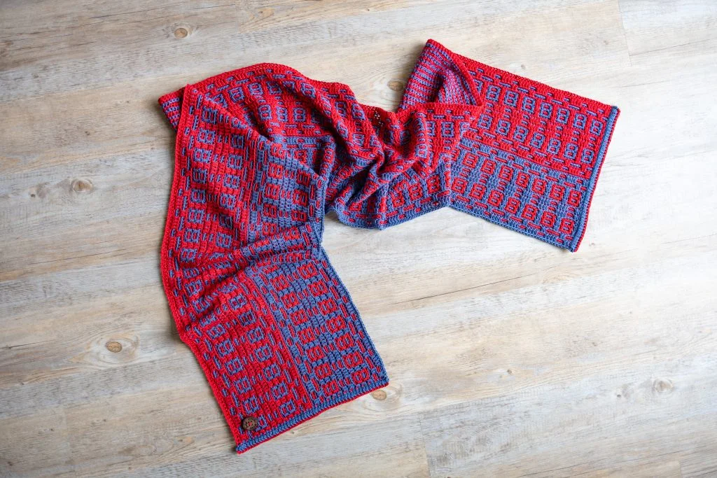 mosaic crochet scarf in blue and red on a floor