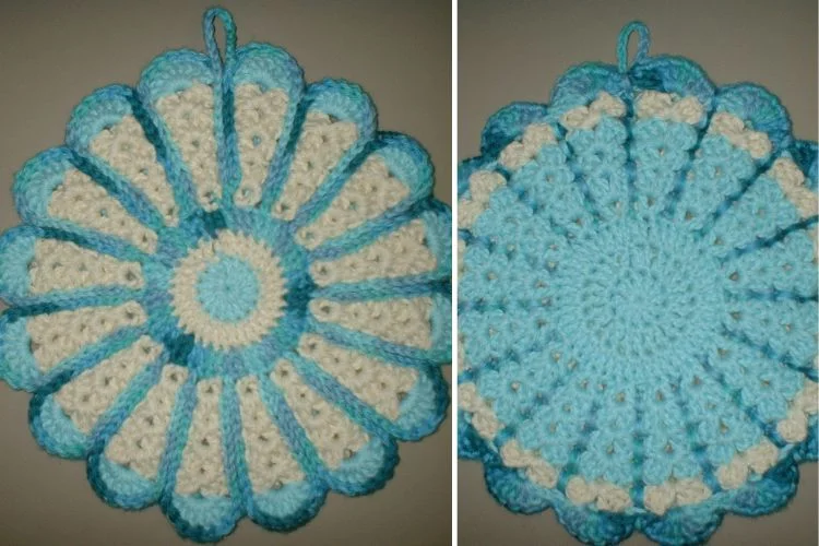 a blue crochet camomile pot holder