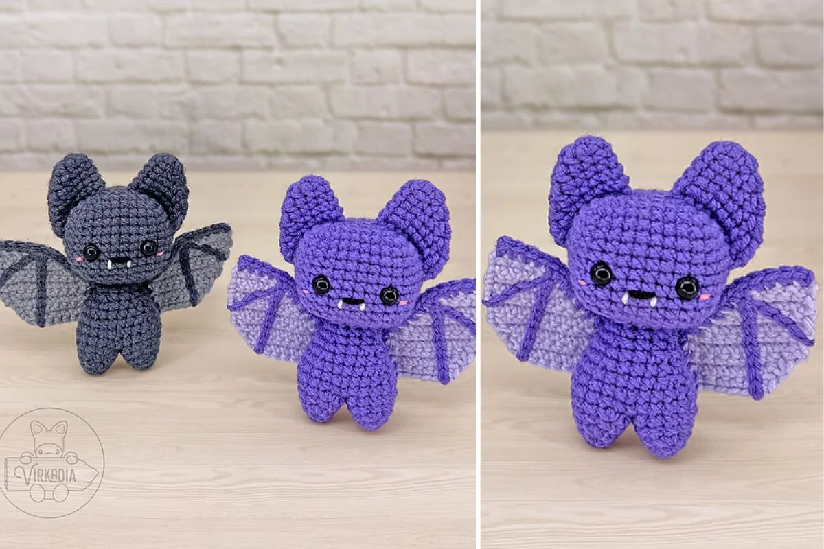 Two crocheted bat plush toys, one gray and one purple, with large ears and wings, are artfully arranged on a light wood surface, showcasing a creative auto draft of whimsical design.