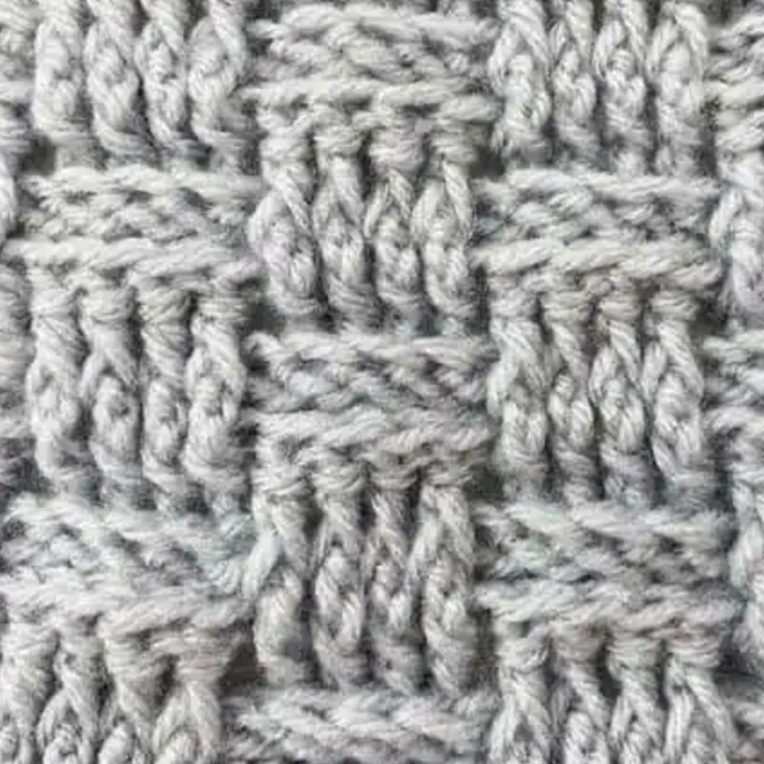 Close-up of a gray knitted textile with a basketweave pattern.