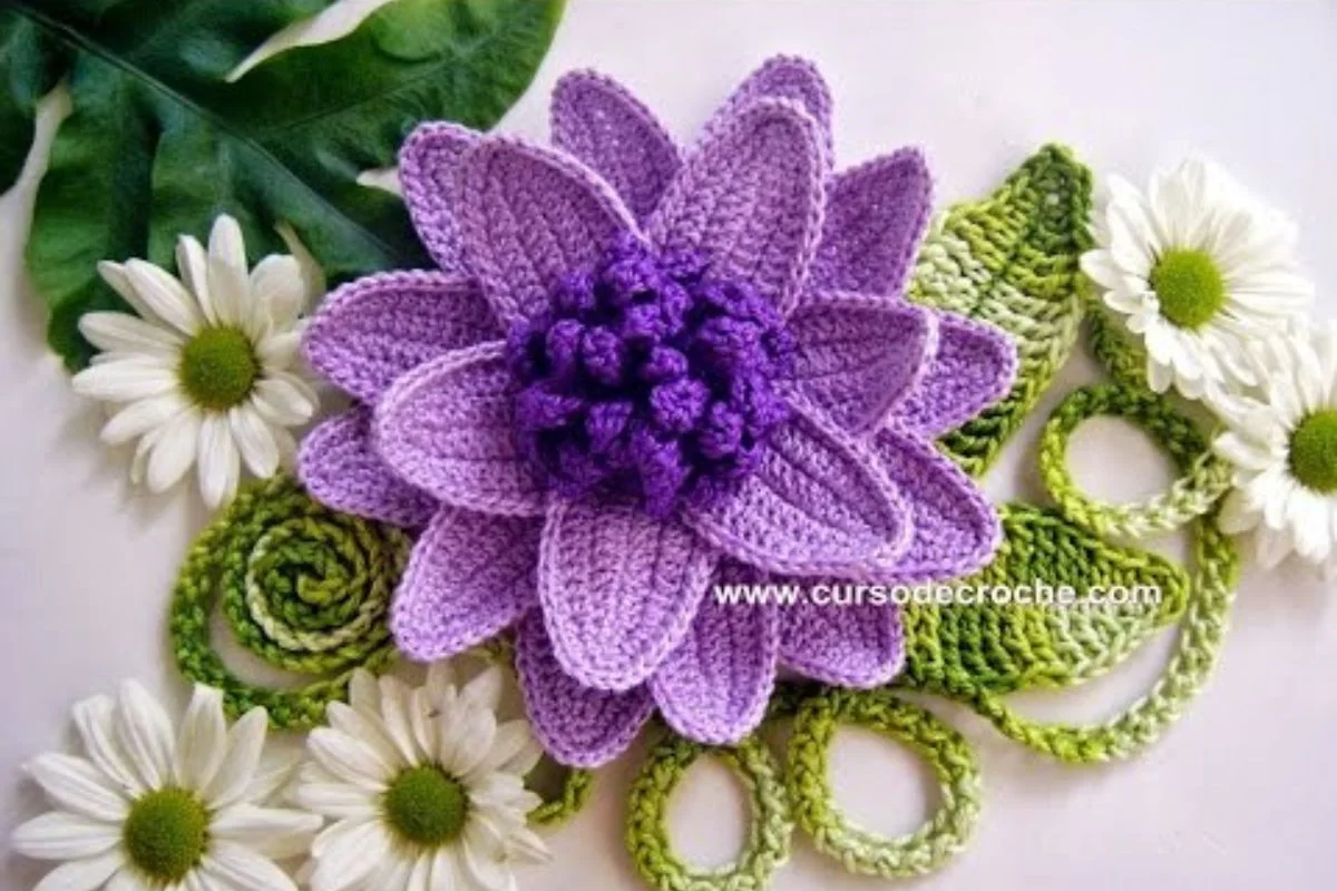 A crocheted purple flower with intricate petals is artfully surrounded by white daisies and lush green leaves, creating a vivid splash of color on the flat surface.