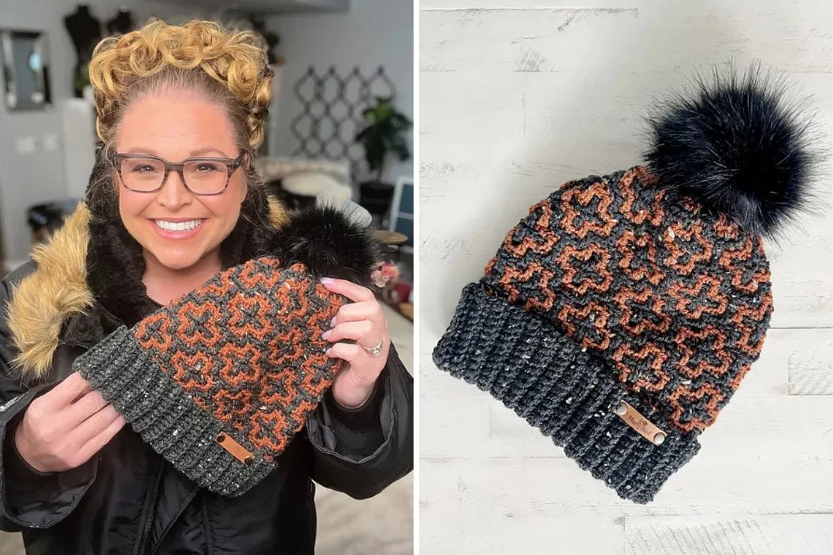 A person holds a knitted beanie with a black pom-pom and an orange pattern, perfectly capturing the essence of Autumn. The cozy hat is displayed prominently on the right side, ready to brave chilly breezes.