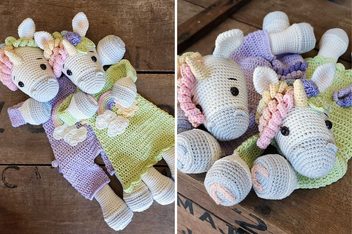 Two crocheted Rainbow Unicorn dolls with pastel-colored manes and tails, wearing purple and green outfits, rest on a wooden surface.