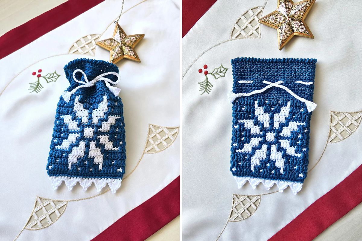 A blue and white crocheted gift bag, adorned with a snowflake pattern, rests on a holiday-themed tablecloth. Accented by a decorative gold star, it perfectly captures the Christmas spirit.