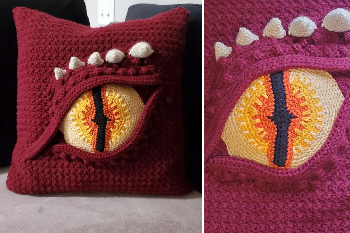 a crochet pillow with a dragon eye design