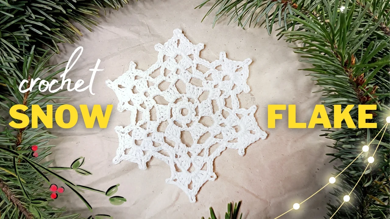 Noelle Crochet Snowflake delicately showcased amidst lush green pine branches, with "crochet snowflake" elegantly displayed in yellow and white letters.