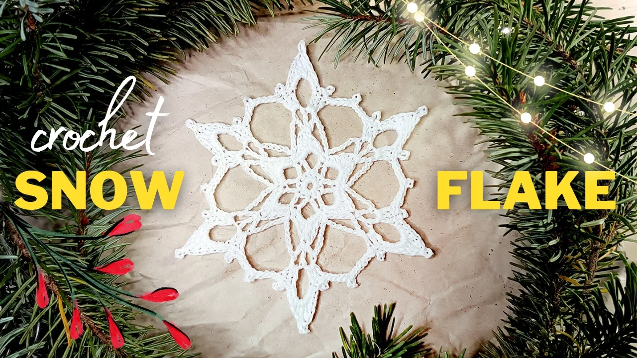 A white Noelle crochet snowflake graces brown paper, encircled by evergreen branches adorned with red berries and twinkling string lights. Text reads "crochet SNOW FLAKE.